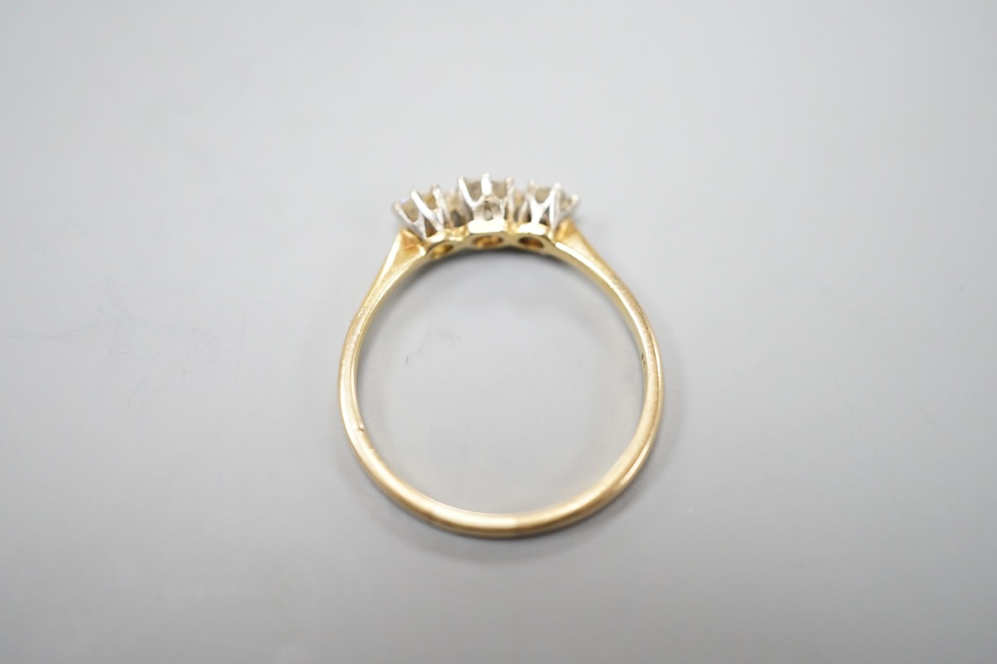 An 18ct and three stone diamond set ring, size P/Q, gross weight 1.7 grams.